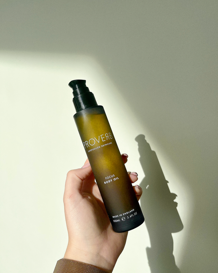 Hand presenting Proverb Focus Body Oil, the perfect addition to a mindful wellness routine