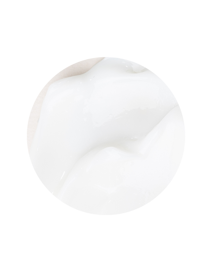 Close-up of Awake Organics Coconut and Sesame Hair Conditioner's creamy texture on a white surface