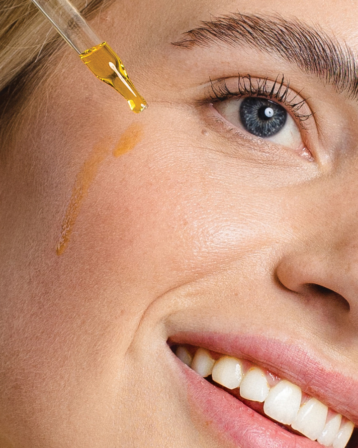 Application of Awake Organics A+C+E Vitamins Brightening Serum on a woman's cheek