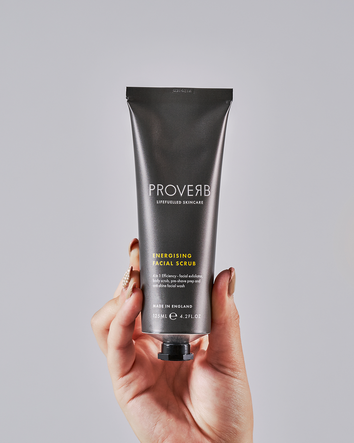 Close-up of a hand holding the Proverb Energizing Facial Scrub, ready to revitalize your skincare routine